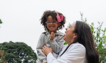 La mujer juega con un niño o una nieta que sonríe y es feliz