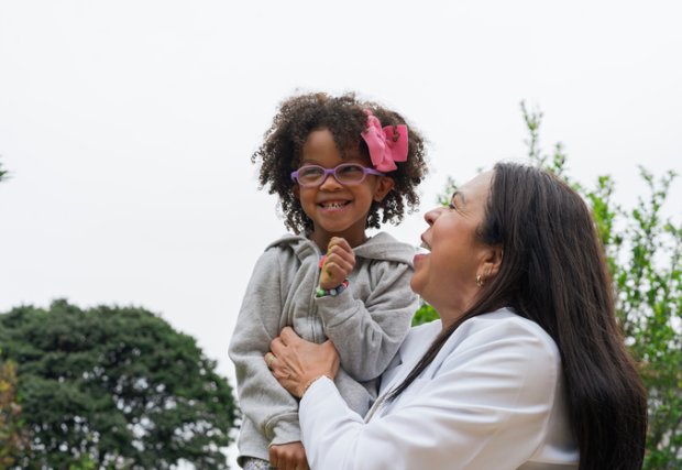 La mujer juega con un niño o una nieta que sonríe y es feliz