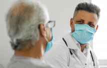 Doctor speaks to patient while masked